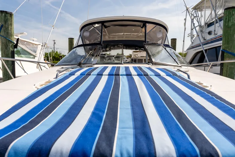 Slide: The Image of 2008 Regal Commodore 4060 yacht with blue striped deck cover at marina. - 22