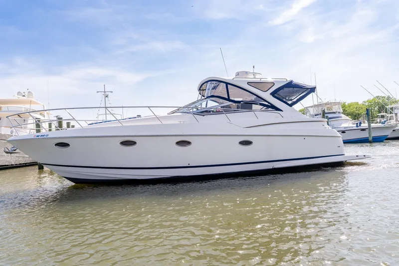 Slide: The Image of 2008 Regal Commodore 4060 yacht docked in a marina under a clear blue sky. - 4