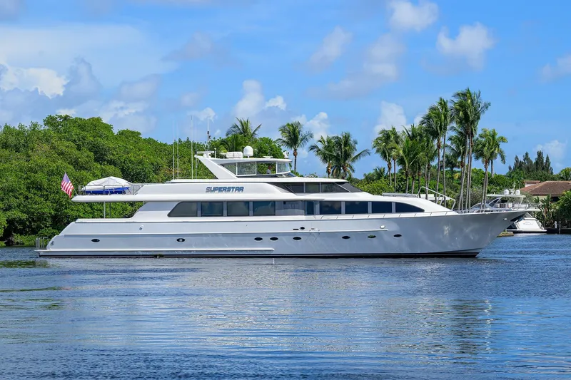 Slide: The Image of 2001 Westport Motor Yacht Raised Pilothouse on tranquil water, surrounded by lush greenery. - 0