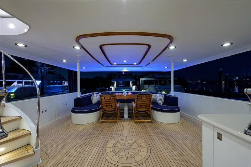 Slide: The Image of Luxurious 2001 Westport Motor Yacht Raised Pilothouse deck at night, featuring elegant seating and lighting. - 1