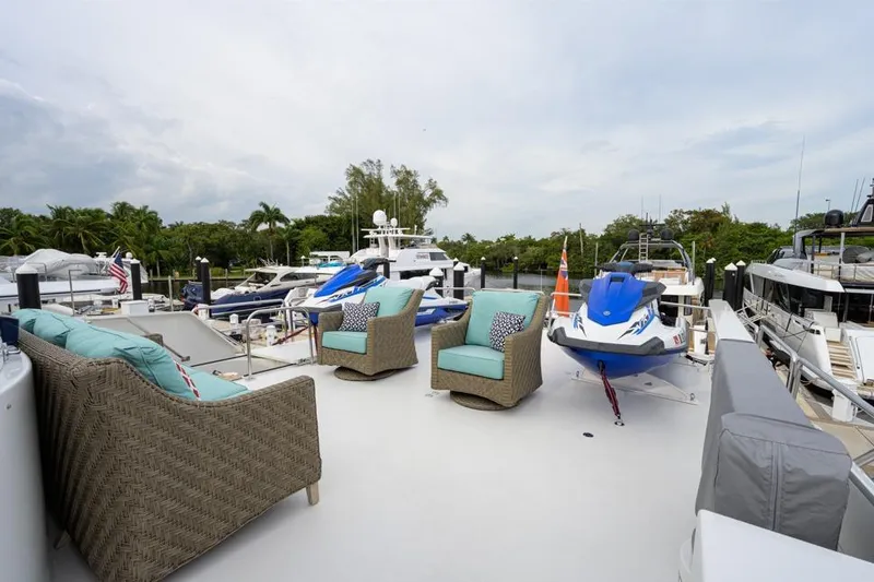 Slide: The Image of Luxurious 2001 Westport Motor Yacht deck with seating and jet ski, docked in marina. - 12