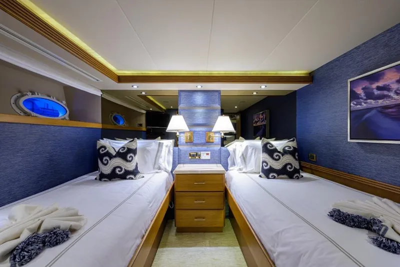 Slide: The Image of Luxurious twin cabin in 2001 Westport Motor Yacht Raised Pilothouse, featuring elegant decor and ambient lighting. - 58
