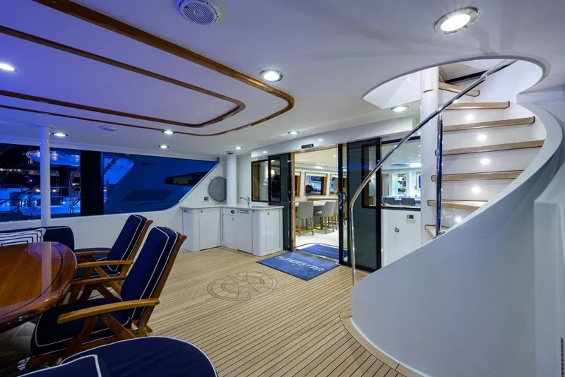 Slide: The Image of Luxurious 2001 Westport Motor Yacht Raised Pilothouse interior with elegant seating and spiral staircase. - 6