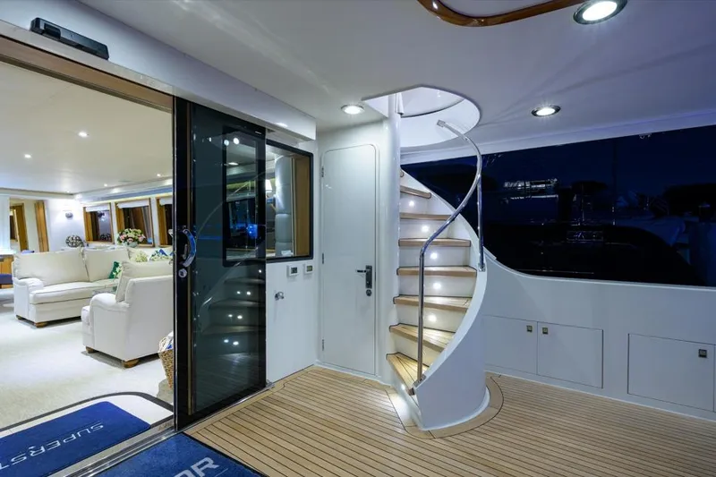 Slide: The Image of Luxurious 2001 Westport Motor Yacht interior with spiral staircase and elegant seating area. - 7