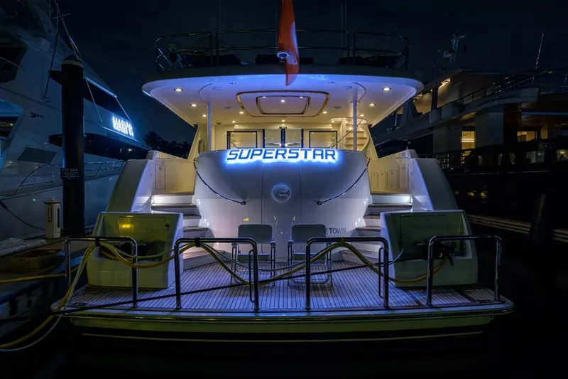 Slide: The Image of Rear view of 2001 Westport Motor Yacht Raised Pilothouse, illuminated at night with "Superstar" sign. - 72