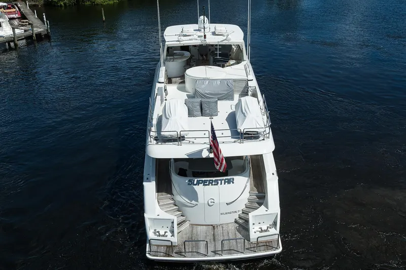 Slide: The Image of 2001 Westport Motor Yacht Raised Pilothouse on water, rear view with American flag. - 92