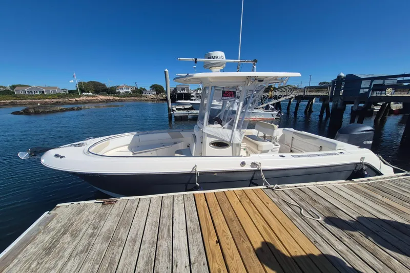 Slide: The Image of 2015 Robalo R242 Center Console boat docked, clear sky, "For Sale" sign visible. - 1