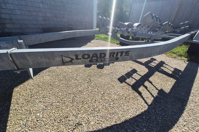 Slide: The Image of Trailer for 2015 Robalo R242 Center Console, Load Rite brand, on gravel surface. - 15