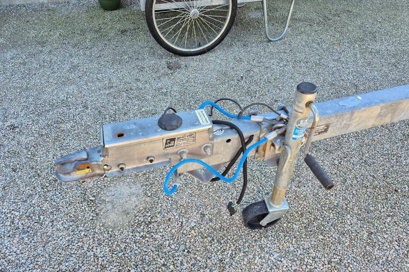 Slide: The Image of Trailer hitch and wheel on gravel, possibly for a 2015 Robalo R242 Center Console boat. - 18