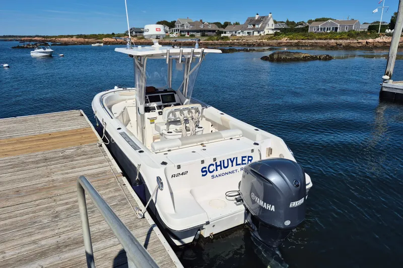 Slide: The Image of 2015 Robalo R242 Center Console boat docked by the water. - 2