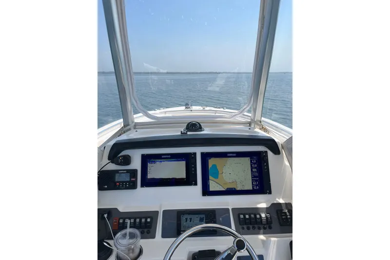 Slide: The Image of 2015 Robalo R242 Center Console dashboard with navigation screens on open water. - 20