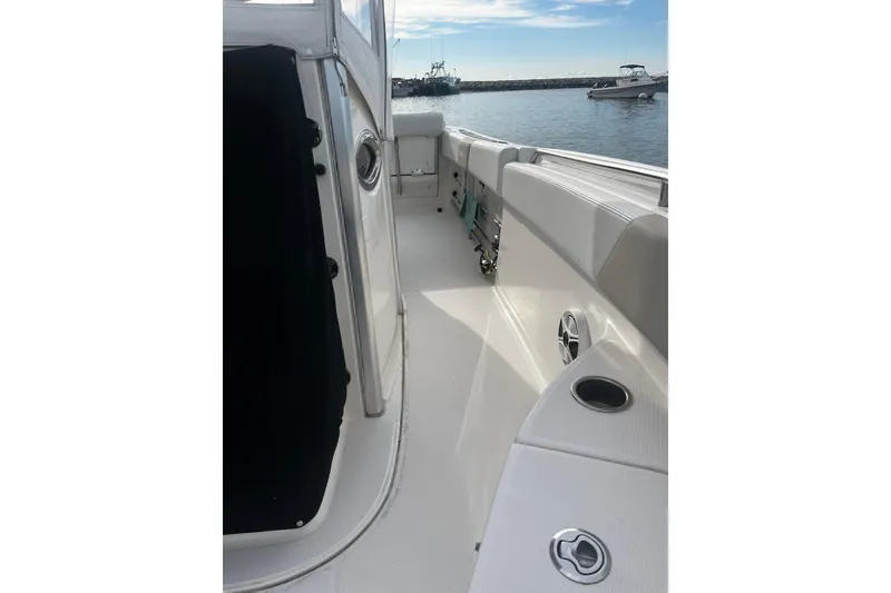Slide: The Image of 2015 Robalo R242 Center Console boat interior with cup holders, docked in calm waters. - 25
