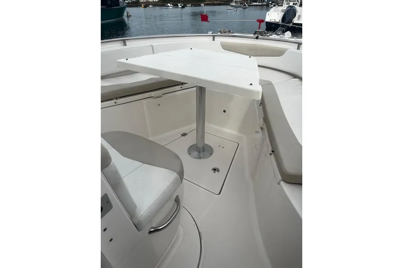 Slide: The Image of 2015 Robalo R242 Center Console boat interior with seating and table, docked at marina. - 30