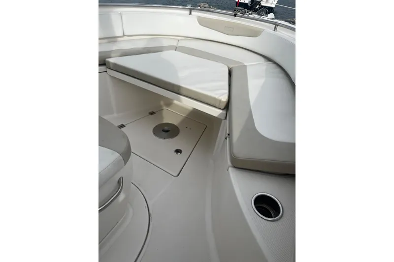 Slide: The Image of 2015 Robalo R242 Center Console boat interior with cushioned seating and storage. - 32