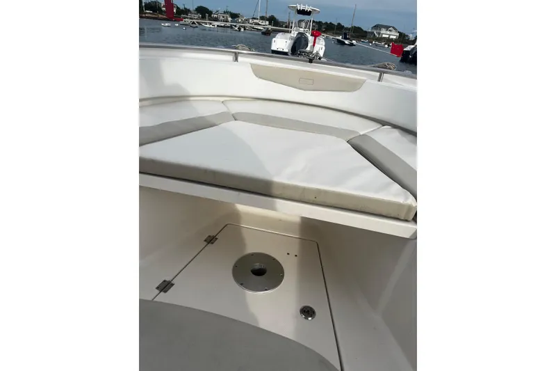 Slide: The Image of 2015 Robalo R242 Center Console boat interior with cushioned seating and storage compartment. - 33