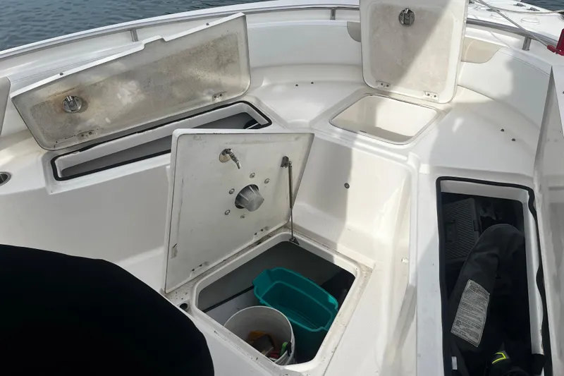 Slide: The Image of 2015 Robalo R242 Center Console boat with open storage compartments and visible gear. - 34