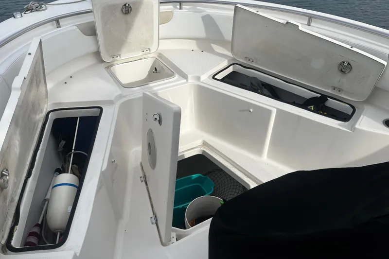Slide: The Image of 2015 Robalo R242 Center Console boat storage compartments open, showing interior organization. - 35