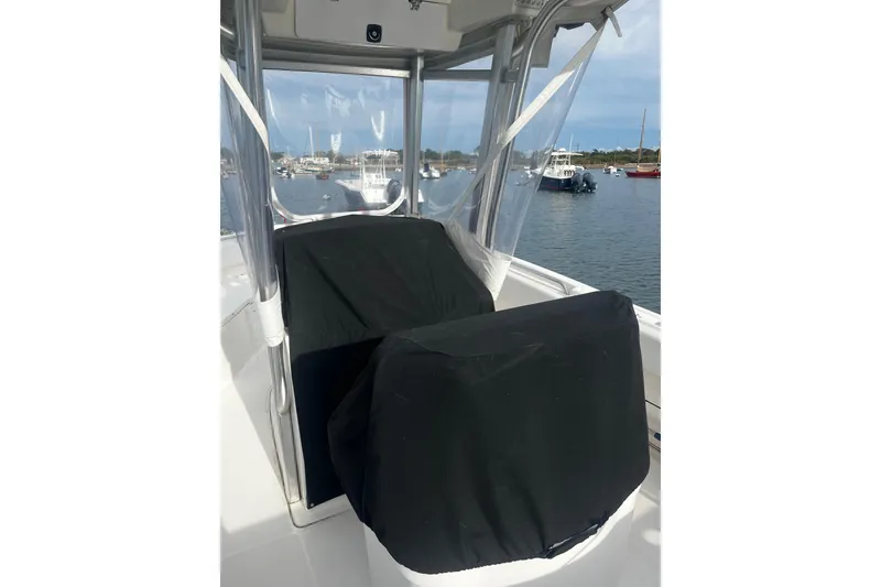 Slide: The Image of 2015 Robalo R242 Center Console boat with covered seats, docked in a marina. - 36