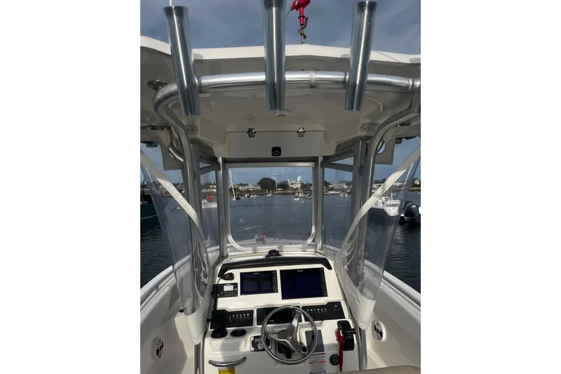 Slide: The Image of 2015 Robalo R242 Center Console boat interior with navigation equipment and rod holders. - 38