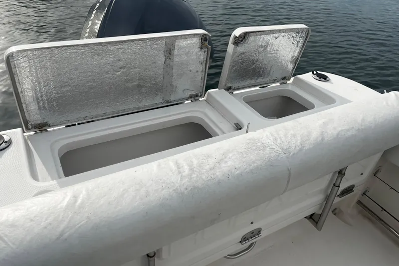 Slide: The Image of 2015 Robalo R242 Center Console boat with open storage compartments on deck. - 46