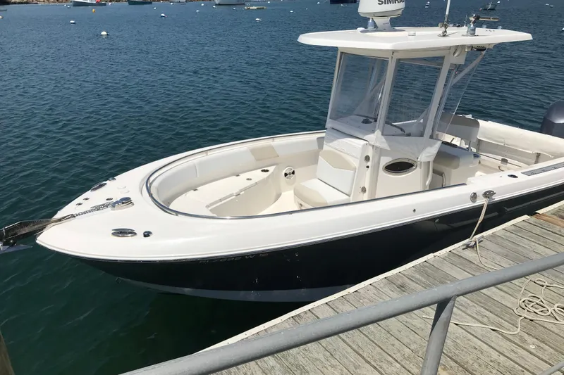 Slide: The Image of 2015 Robalo R242 Center Console boat docked on calm water. - 52