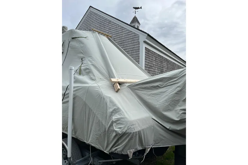 Slide: The Image of Covered 2015 Robalo R242 Center Console boat with a weather vane in the background. - 58