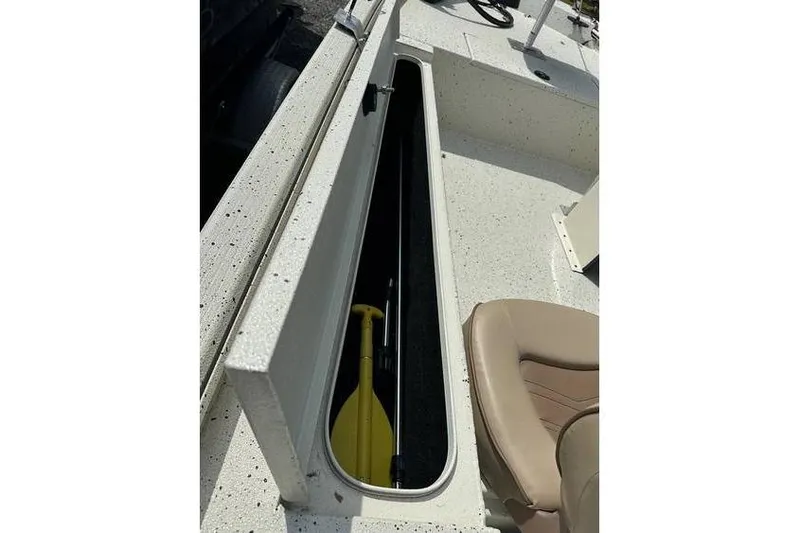 Slide: The Image of 2020 Xpress XP170 boat storage compartment with yellow paddle and beige seat. - 7