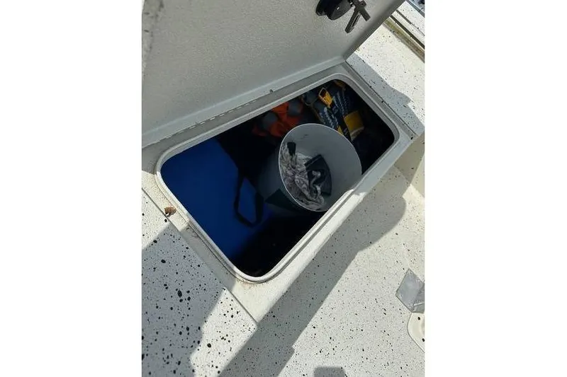 Slide: The Image of Open storage compartment on 2020 Xpress XP170 boat with various items inside. - 9