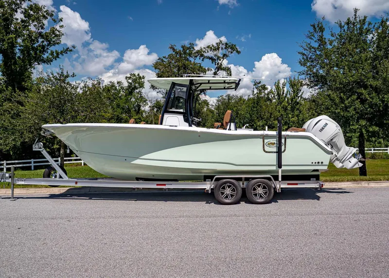 Slide: The Image of 2026 Sea Hunt Ultra 275 SE boat on trailer, parked outdoors under a blue sky. - 2