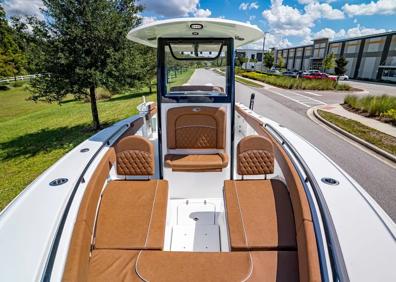 Slide: The Image of 2026 Sea Hunt Ultra 275 SE boat with luxurious brown seating, parked outdoors. - 25