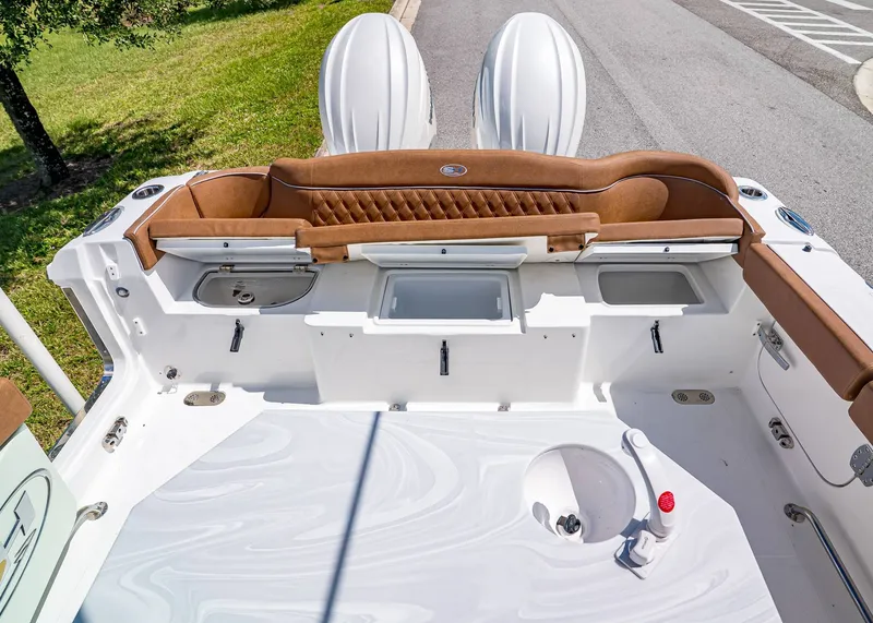 Slide: The Image of 2026 Sea Hunt Ultra 275 SE boat interior with brown seating and storage compartments. - 9