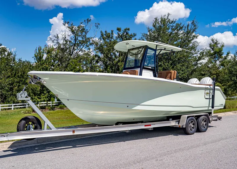 The Image of 2026 Sea Hunt Ultra 275 SE boat on trailer, parked on a sunny day. - 1