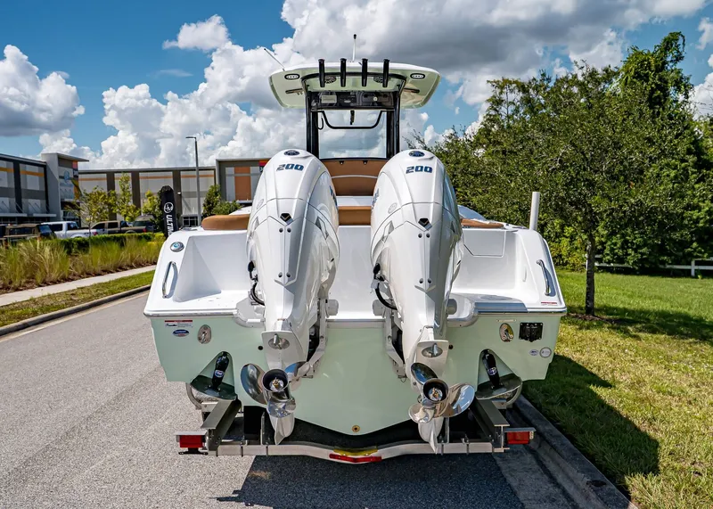 Slide: The Image of 2026 Sea Hunt Ultra 275 SE boat with dual engines, parked on a sunny day. - 4