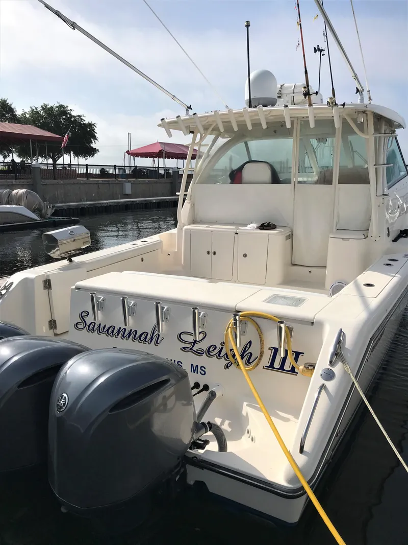 Slide: The Image of 2013 Pursuit OS 385 Offshore boat docked with triple outboard engines. - 5