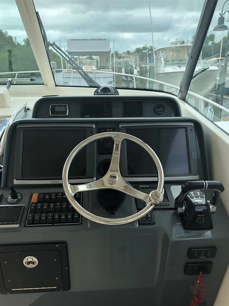 Slide: The Image of 2013 Pursuit OS 385 Offshore boat docked, featuring spacious deck and seating area. - 8