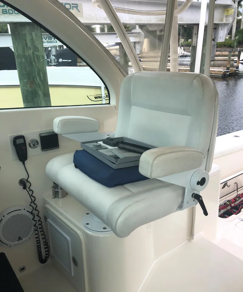 Slide: The Image of 2013 Pursuit OS 385 Offshore boat with blue sunshade, docked outdoors. - 9