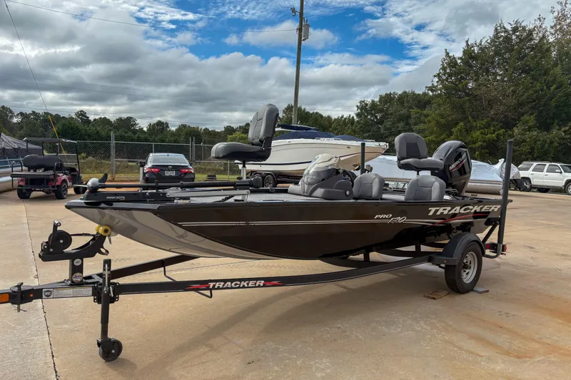 Slide: The Image of 2023 Tracker Pro 170 boat on trailer, parked outdoors under cloudy sky. - 12