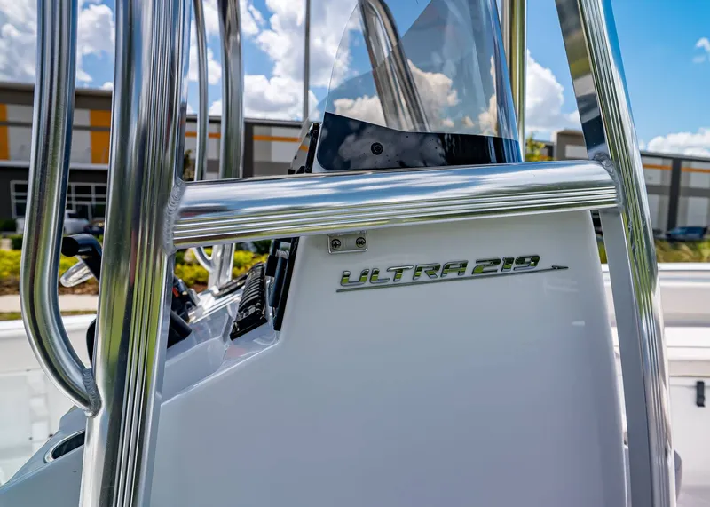 Slide: The Image of 2026 Sea Hunt Ultra 219 boat console with chrome details and clear windshield. - 13
