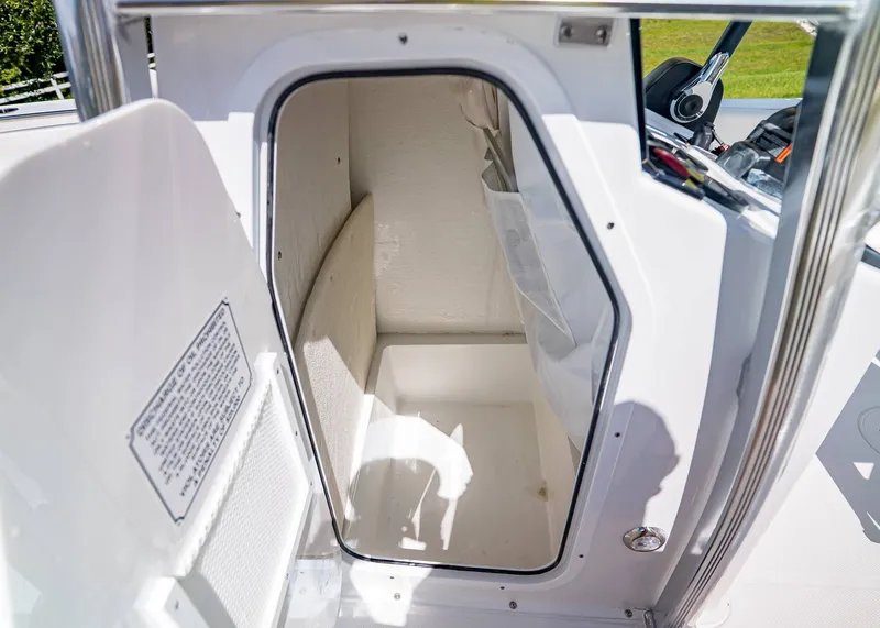 Slide: The Image of Storage compartment inside 2026 Sea Hunt Ultra 219 boat, featuring clean white interior. - 16