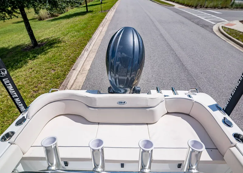 Slide: The Image of 2026 Sea Hunt Ultra 219 boat with outboard motor on a road, rear view. - 4