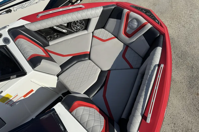 Slide: The Image of 2019 Tigé ZX1 boat interior with red and gray seating, diamond stitching, and cup holders. - 7