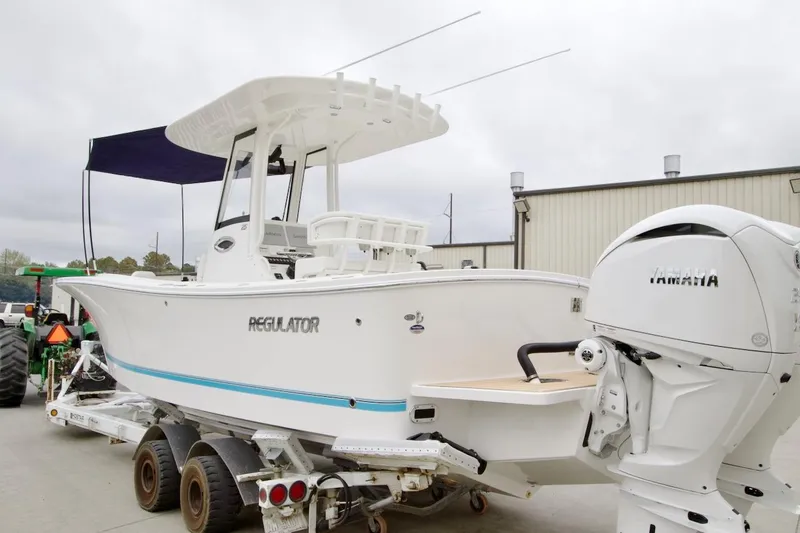 The Image of 2026 Regulator 25 boat with Yamaha engine on trailer, parked outdoors. - 0