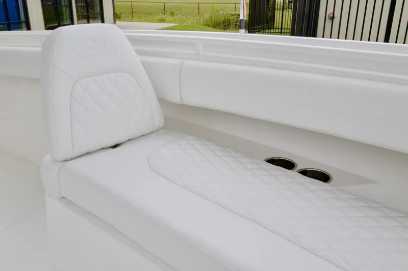 Slide: The Image of 2026 Regulator 25 boat with white quilted seating and cup holders. - 11