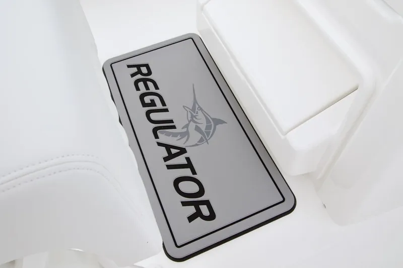 Slide: The Image of 2026 Regulator 25 boat interior with branded floor mat and white seating. - 17