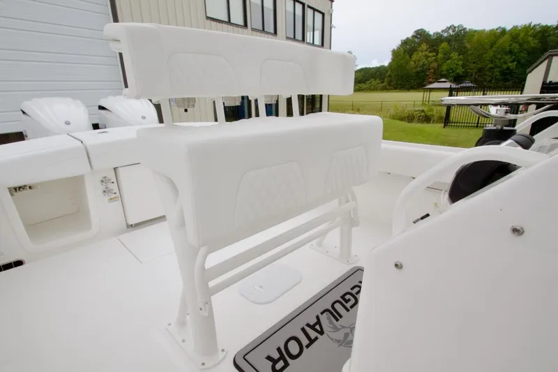 Slide: The Image of 2026 Regulator 25 boat interior with white seating and dual outboard engines. - 18