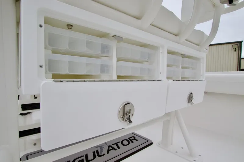 Slide: The Image of 2026 Regulator 25 boat storage compartments with secure latches and organized tackle boxes. - 25