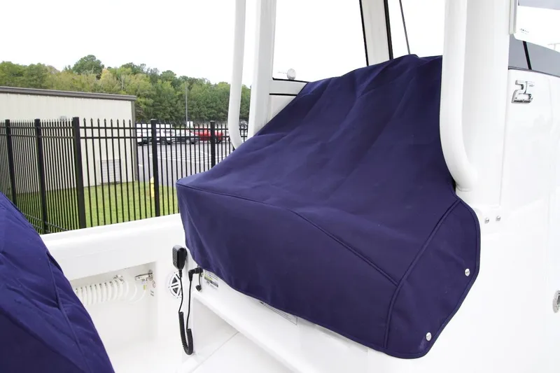 Slide: The Image of 2026 Regulator 25 boat with blue console cover, outdoor setting. - 8