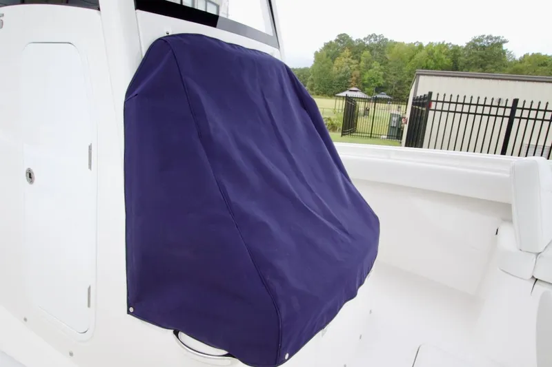 Slide: The Image of 2026 Regulator 25 boat with a blue console cover, white interior, and outdoor setting. - 9