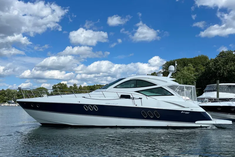 The Image of 2010 Cruisers Yachts 520 Sports Coupe on a serene lake under a blue sky. - 0