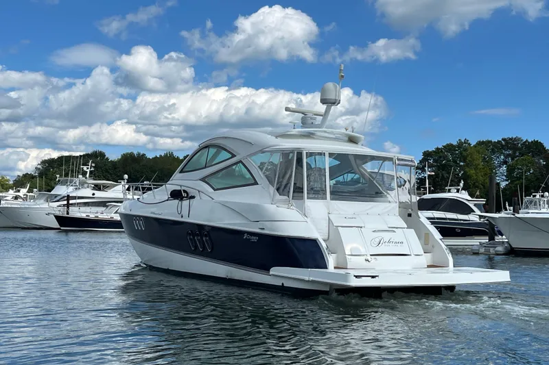 Slide: The Image of Luxurious seating area on a 2010 Cruisers Yachts 520 Sports Coupe, featuring elegant white upholstery. - 12